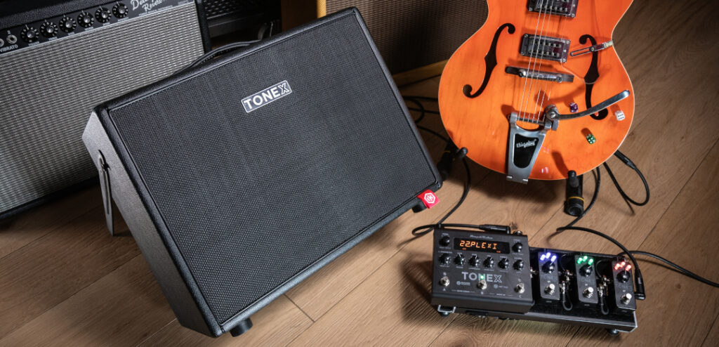 IK Multimedia TONEX Cab Lifestyle Produktfoto der IK Multimedia TONEX Cab mit E-Gitarre und Effektpedalen.