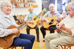 Vier Senioren beim Gitarre Spielen.
