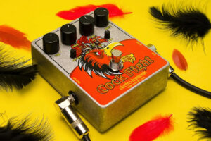 Electro Harmonix Cock Fight Pedal Produktbild des Electro Harmonix Cock Fight Fuzz Effektpedal mit gelbem Hintergrund und Federn, passend zum Namen.