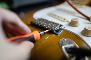 Einstellen der Intonation einer E-Gitarre.