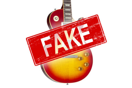 Bannerbild einer gefälschten E-Gitarre mit "Fake"-Stempel.