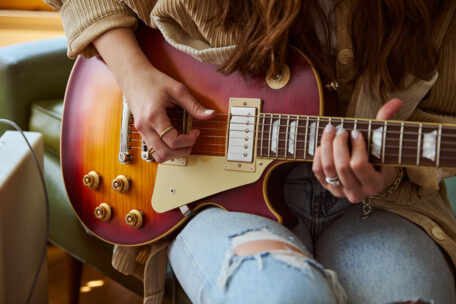Symbolbild einer Gitarristin, die eine Gibson Les Paul spielt.