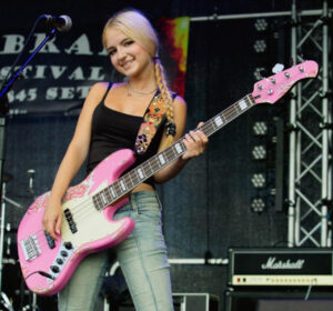 Polina Zagnoi von The Sixsters Fame Custom JB 4 Worn Shell Pink over Pink Paisley. Polina Zagnoi von The Sixsters spielt den Fame Custom JB 4 Worn Shell Pink over Pink Paisley. E-Bass.