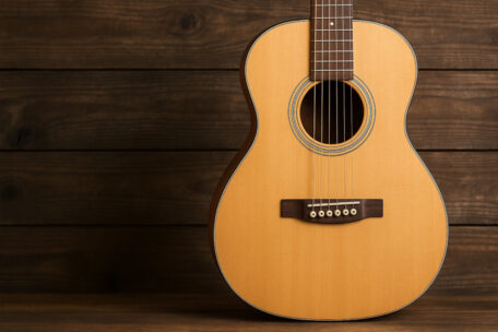 Akustikgitarre vor Hintergrund aus Holz