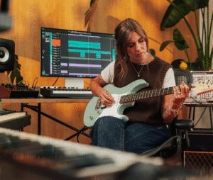 Gitarristin mit E-Gitarre im Home Studio.