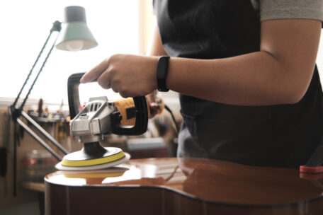 Mann trägt Gitarrenlack auf